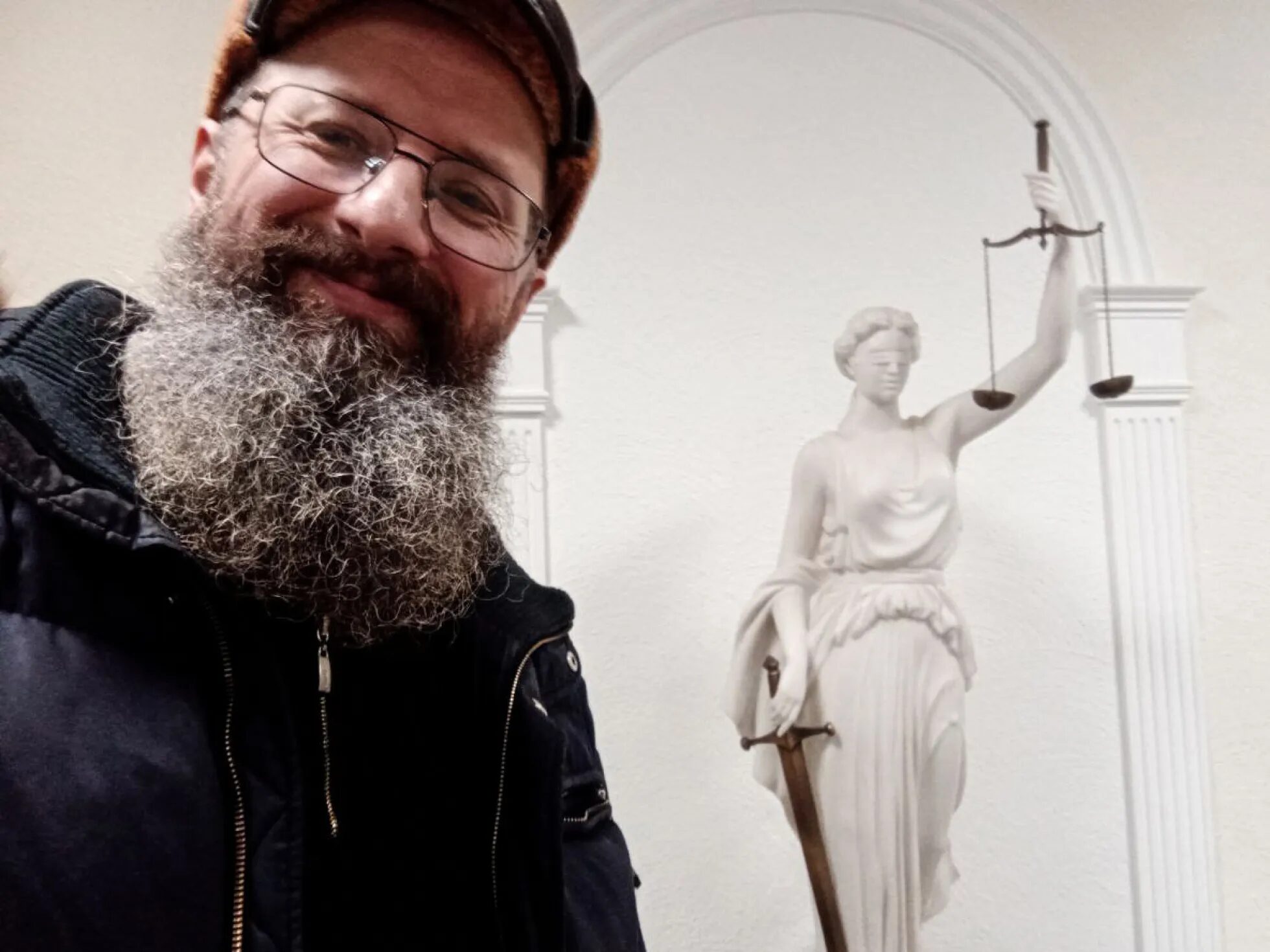 Dmitri Skurichin posiert vor einer Statue der Justitia. Er war seit vielen Jahren politisch aktiv, auch als Abgeordneter. Für seinen Protest gegen den Krieg schickte ihn ein Gericht für anderthalb Jahre in ein Straflager / Foto © privat